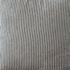 Striped pillow on a wooden chair against a plain wall
