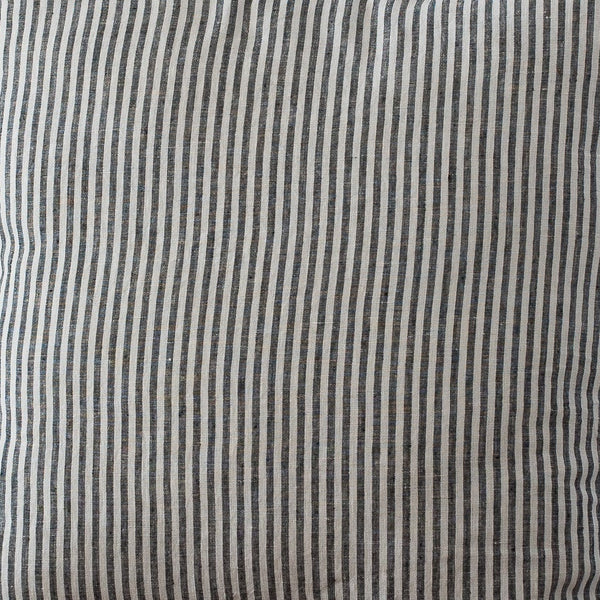 Striped pillow on a wooden chair against a plain wall