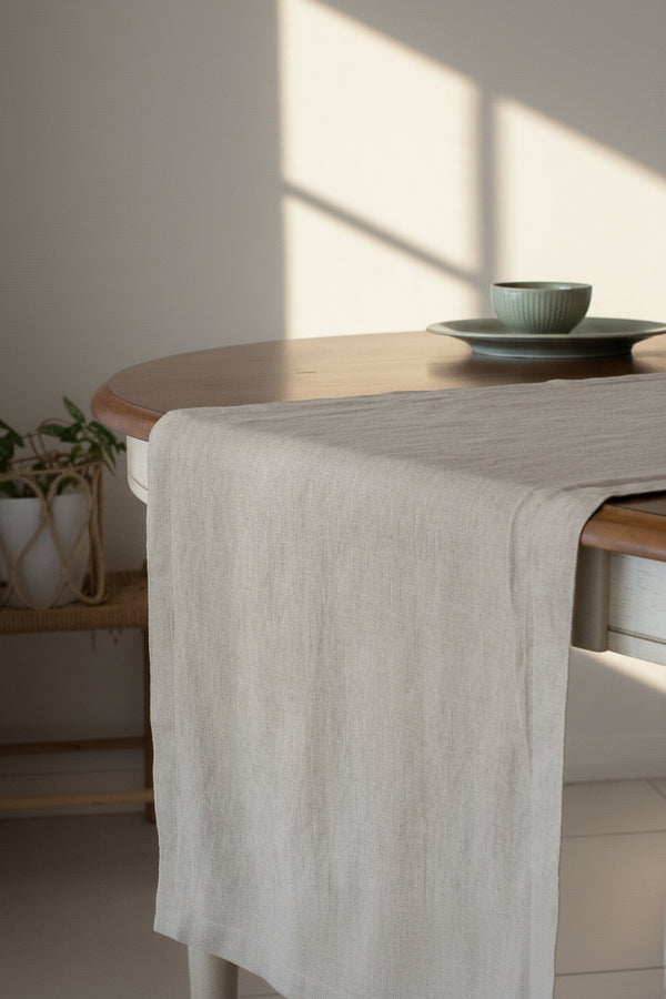 Dining table with a beige runner and a bowl on a gray background