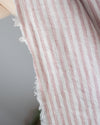Close-up of a sleeveless garment with pink and white striped pattern on a blurred background