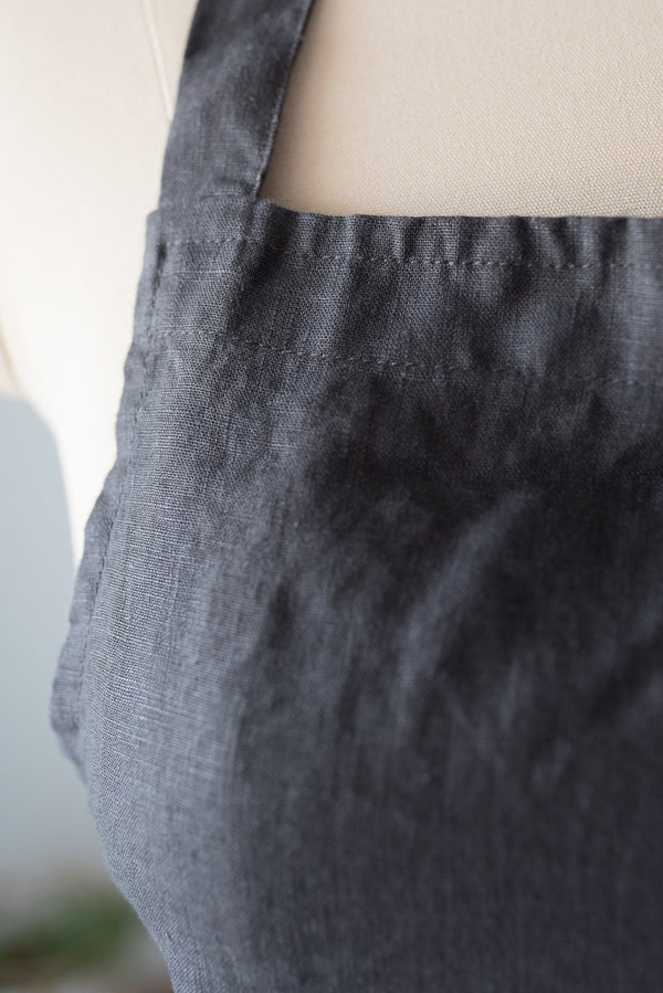 Close-up of dark gray pants on a mannequin with a blurred background