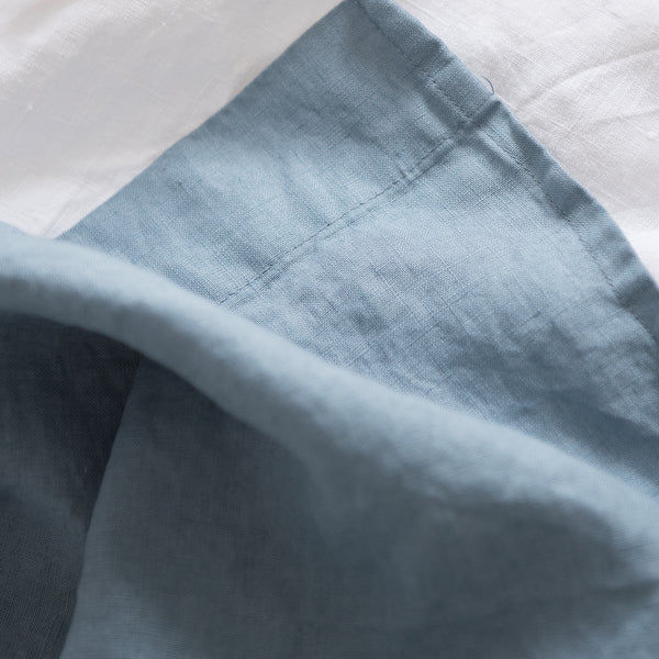 Close-up of Lake Blue flat sheet 100% linen with a white background