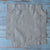 Two Natural 100% Linen Cocktail Napkins on a rustic wooden surface