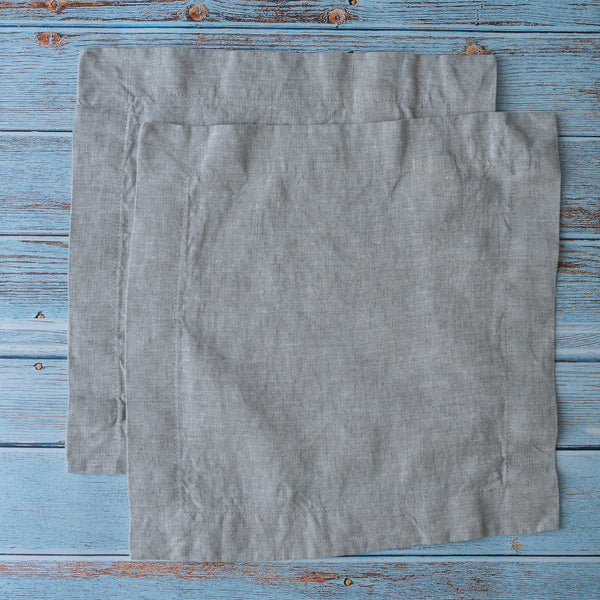 Two Natural 100% Linen Cocktail Napkins on a rustic wooden surface