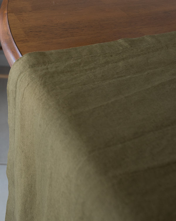 olive table runner on wooden dining table