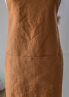 Brown apron on a person against a neutral background