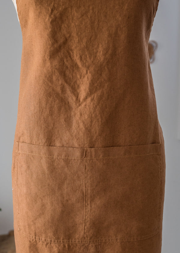 Brown apron on a person against a neutral background