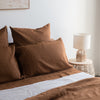 Tobacco Brown bedding set on a bed with a lamp and side table in the background.