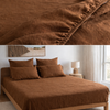Tobacco brown 100% linen fitted sheet on bed with pillows and linen curtain in a minimalist bedroom