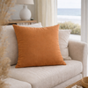 clay pillow on a beige sofa in a living room with a window in the background