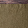Close-up of Olive 100% Linen Placemat with a wooden surface above