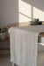 Dining table with a beige runner and a bowl on a gray background