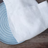 white linenon a wooden surface with a blue circular object underneath