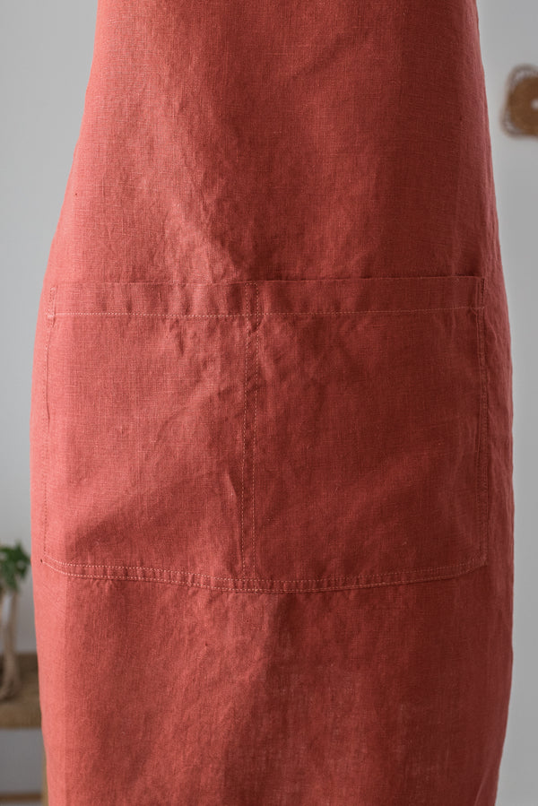 Close-up of a red apron with a pocket on a plain background