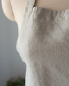 Close-up of a beige apron on a mannequin against a neutral background