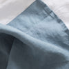 Close-up of Lake Blue flat sheet 100% linen with a white background