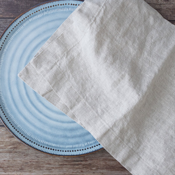 Light naturalnapkin on a blue ceramic plate with a wooden surface background