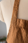Brown apron on a mannequin with a neutral background