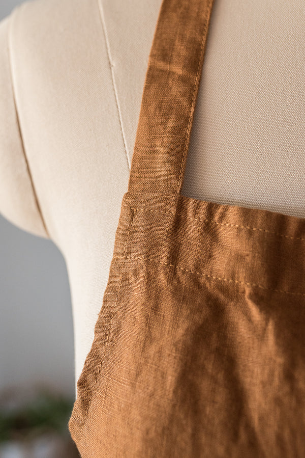 Brown apron on a mannequin with a neutral background
