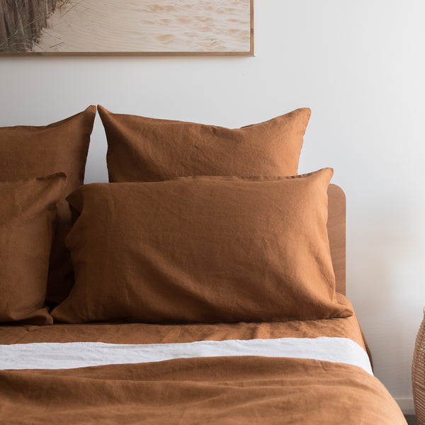 Tobacco Brown bedding set on a bed with a neutral wall and framed picture in the background